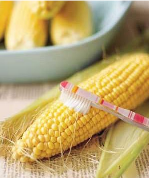 The bristles from a toothbrush will remove stray threads of silk from freshly shucked ears of corn. 