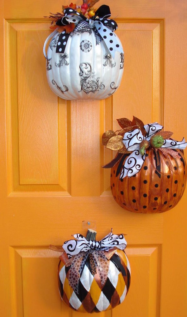 Buy fake pumpkins from the $1 store, cut them in half, decorate the outside, and hang them on your front door! SO smart and pretty!
