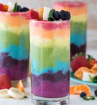 Beautiful 7 layer rainbow smoothie recipe! Full of tons of fruit and topped with a fruit skewer, it’s the ultimate rainbow smoothie!