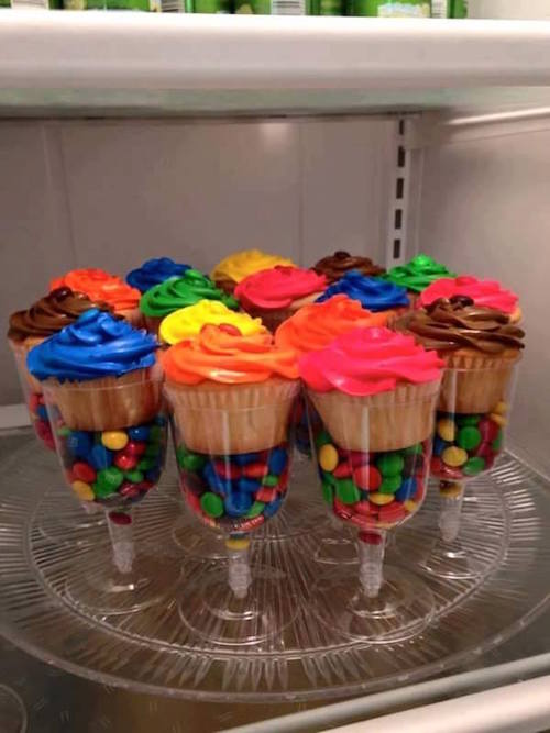 DIY cupcake stands - so colorful! Get plastic wine glasses from the dollar store, fill the bottom with M&M's (or color coordinating candies) and put the cupcakes on top. Great idea! 