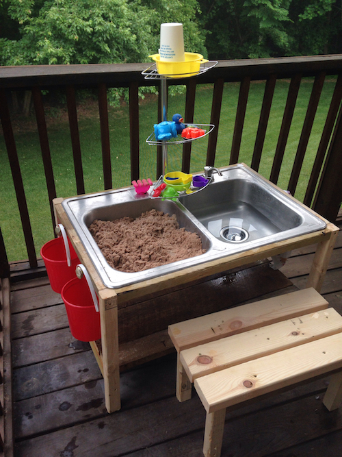 This is a DIY water table for kids made from a thrift store kitchen sink! They used pallet wood around it and even put in a couple of knobs for the buckets on the side. My kids would love this! 