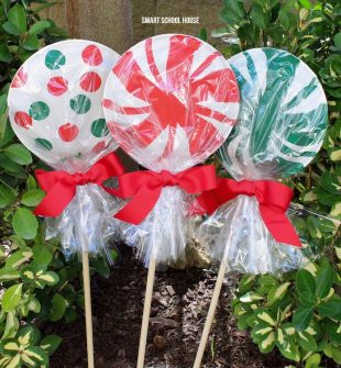 Giant paper plate lollipops for Christmas - Super cute as a garden Christmas decoration or line your driveway with them! They cost less than a dollar each to make!