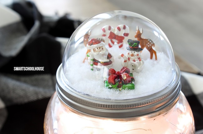 How to make a Mason Jar Lid Snow Globe for Christmas using a clear plastic ornament. ADORABLE! Easy for everybody to do! DIY Christmas gift in a jar idea.