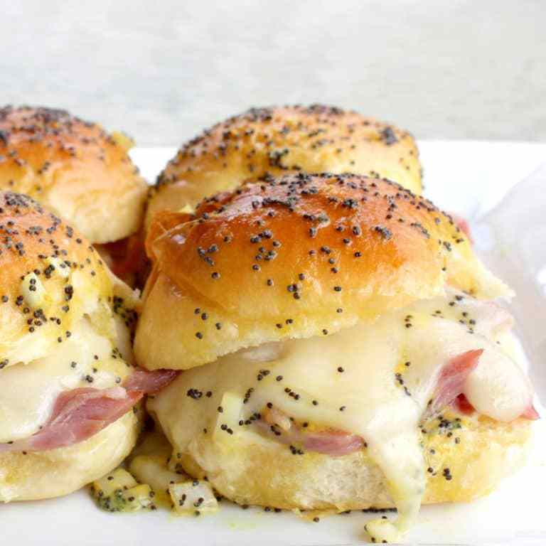 Baked Ham and Cheese Sliders - A delicious warm sandwich filled with swiss cheese, ham, and topped with a buttery mustard poppyseed sauce. YUM!