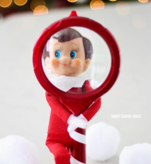 He's always watching! How to make an Elf on the Shelf looking through a Magnifying glass for Christmas. #ElfOnTheShelf #ElfOnTheShelfIdea #ElfOnTheShelfIdeas #EasyElfOnTheShelfIdea