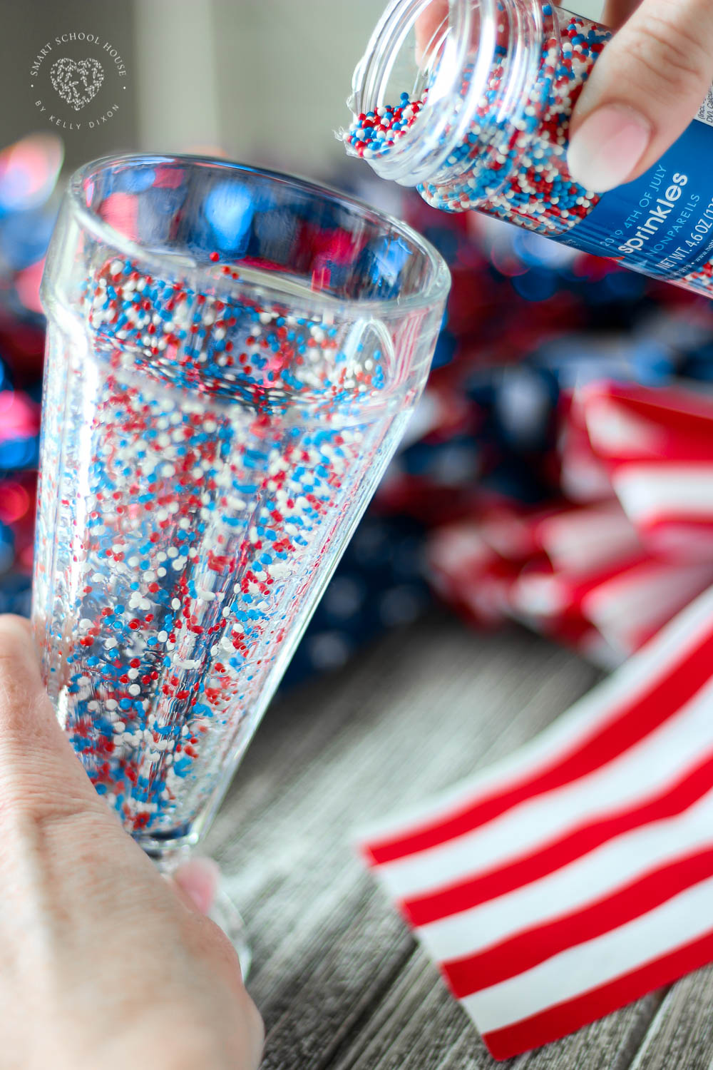 Making a 4th of July milkshake with sprinkles on the sides of the cup. 
