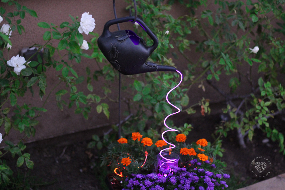 Halloween Watering Can with purple cascading lights and bugs.
