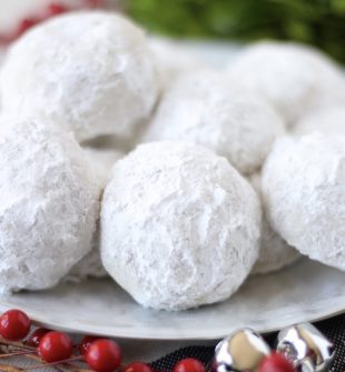 These traditional Snowball Cookies are a beautiful addition to your holiday cookie plates and dessert tables. They have a buttery vanilla flavor surrounded by soft and snowy powdered sugar. Snowball Cookies have a crumbly, buttery, nutty texture that just melts in your mouth and are completely irresistible. These holiday cookies are simply the BEST! Everyone loves this classic Christmas cookie recipe. Snowball Cookies These cookies are sometimes called Russian Tea Cakes or Mexican Wedding Cookies. Whatever you name them in your house, they are sure to be a hit (especially with kiddos in December!). They are special because they are delectable buttery, nutty, round shortbread cookies. We also love them so much because they are covered in powdered sugar that remind us of snowballs and playing in the snow.