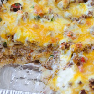 Taco Lasagna is made with soft flour tortillas, seasoned taco ground beef, and pico de gallo. But the cheese is really what makes this Taco Lasagna OVER THE TOP!
