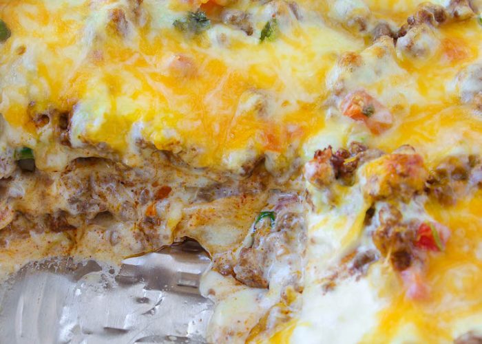 Taco Lasagna is made with soft flour tortillas, seasoned taco ground beef, and pico de gallo. But the cheese is really what makes this Taco Lasagna OVER THE TOP!