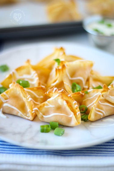 Buffalo Chicken Wontons. Baked, not fried! Creamy buffalo chicken drizzled in dressing! Done in 12 minutes.