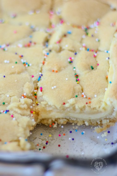 Sugar Cookie Cheesecake Bars - sugar cookie dough surrounding creamy cheesecake filling. A dessert that has the best of both worlds!