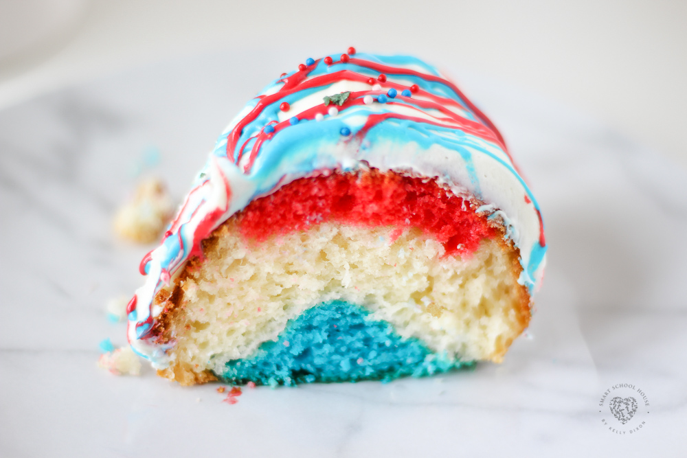 Our EASY Red White and Blue Cake recipe is so pretty with three colorful layers of fluffy cake and patriotic drizzled frosting. It will be a hit for the Fourth of July, Memorial Day, and Flag Day!