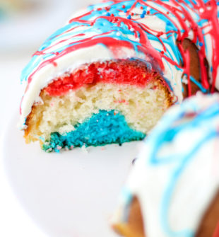 Our EASY Red White and Blue Cake recipe is so pretty with three colorful layers of fluffy cake and patriotic drizzled frosting. It will be a hit for the Fourth of July, Memorial Day, and Flag Day!