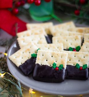 Christmas Crackers use your favorite old fashioned saltine cracker, dipped in chocolate, and adorned with holly sprinkles!