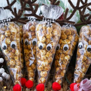 Rudolph is so cute as a Cracker Jack Reindeer! Cone-shaped treat bags filled with caramel corn and topped with pipe cleaner antlers. This is such a cute holiday craft and Christmas gift idea.