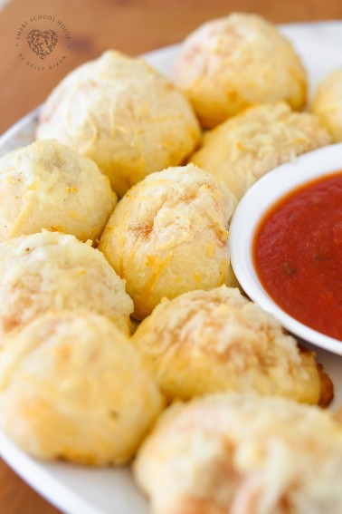 Homemade Pizza Poppers are filled with melted mozzarella cheese and mini pepperoni and then topped with an irresistible cheesy, garlic, butter glaze. Dipped in additional pizza sauce or ranch dressing, these are simply addicting! They are a fun, kid-friendly, finger food recipe for lunch, an after-school snack, or your next party! 