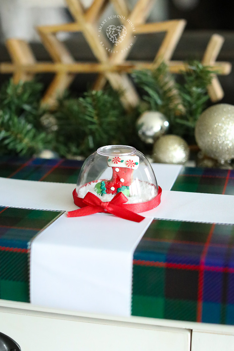 Los envoltorios de regalo de bola de nieve son una forma hermosa de decorar tus regalos de Navidad envueltos.  ¡Esta pequeña y rápida artesanía navideña con forma de bola de nieve hace que las cajas de regalo se vean muy especiales!