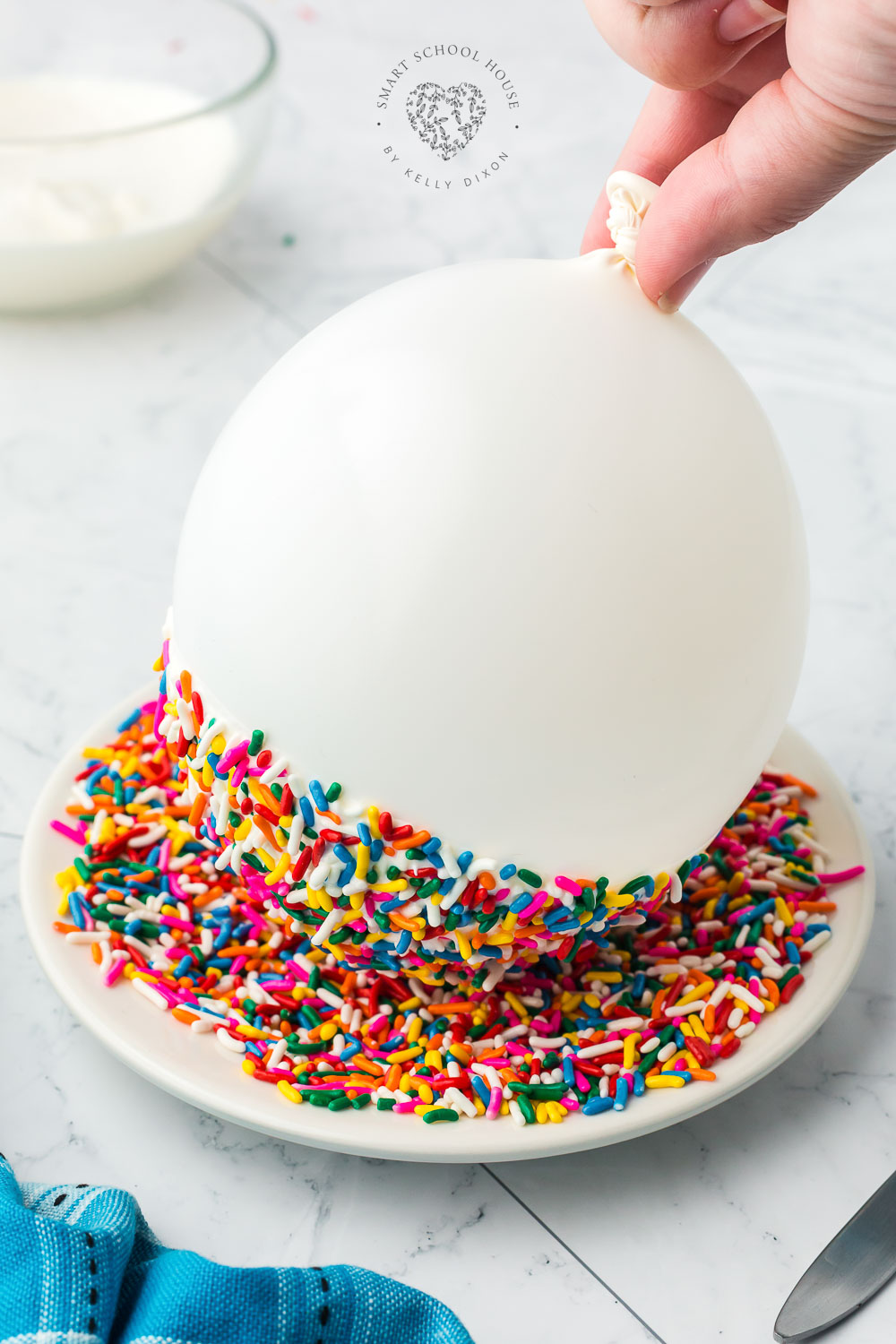 Dipping a balloon into chocolate and sprinkles