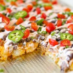 Creamy cheesy Tatchos recipe! Tater tot nachos are layered meat, cheese, and a delicious creamy drizzle!