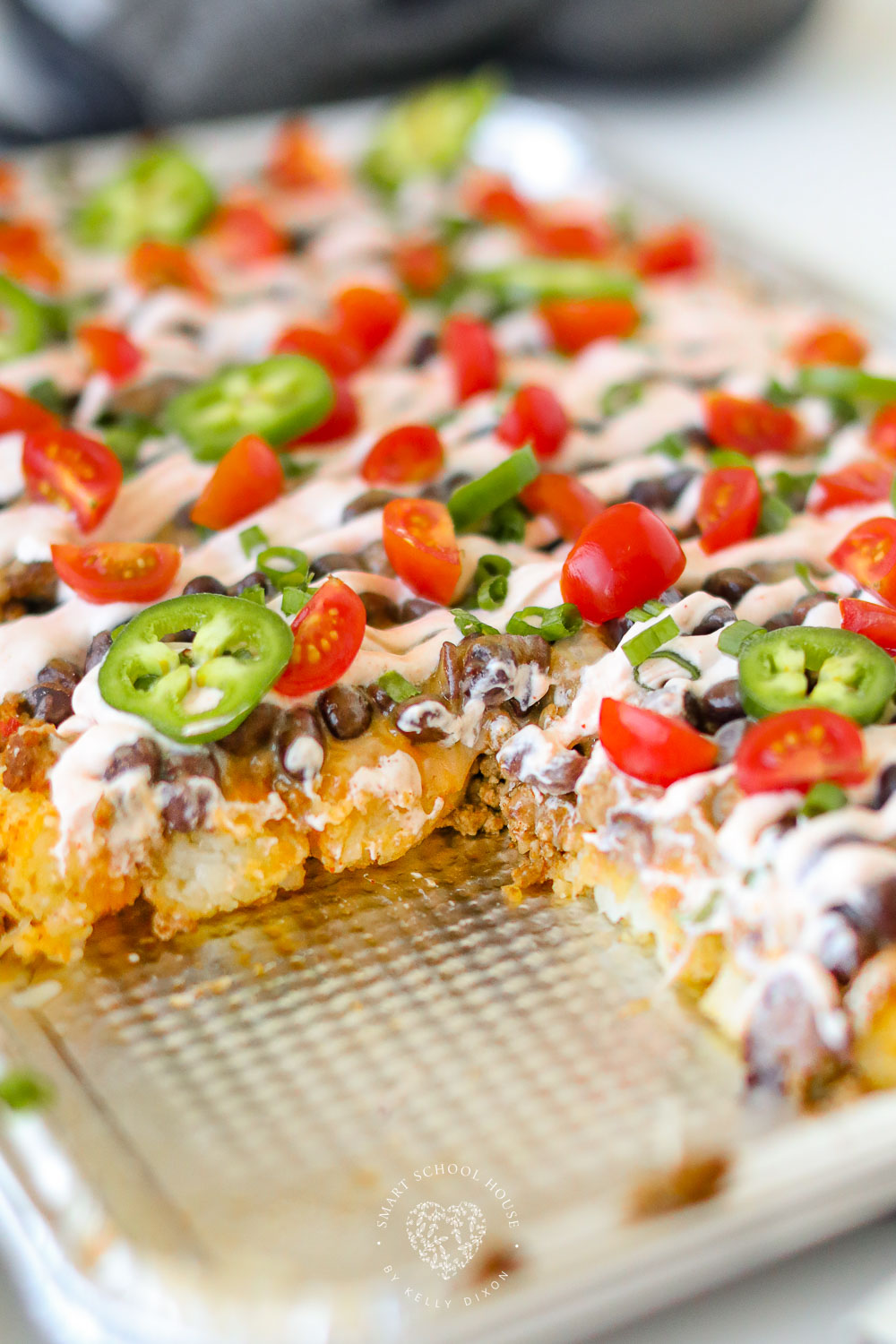 Creamy cheesy Tatchos recipe! Tater tot nachos are layered meat, cheese, and a delicious creamy drizzle! 