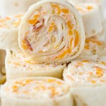 These Tortilla Roll Ups taste like a million dollars! This easy appetizer recipe has flour tortillas rolled around an amazing cheese mixture.