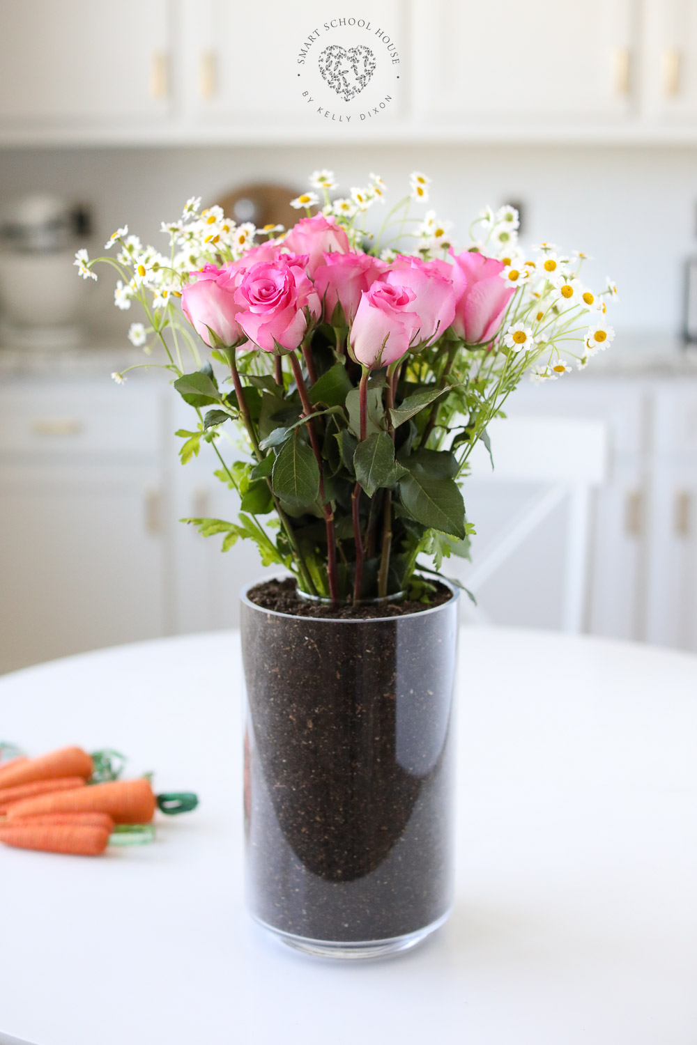 Fresh flowers sit inside of a hidden vase surrounded by soil