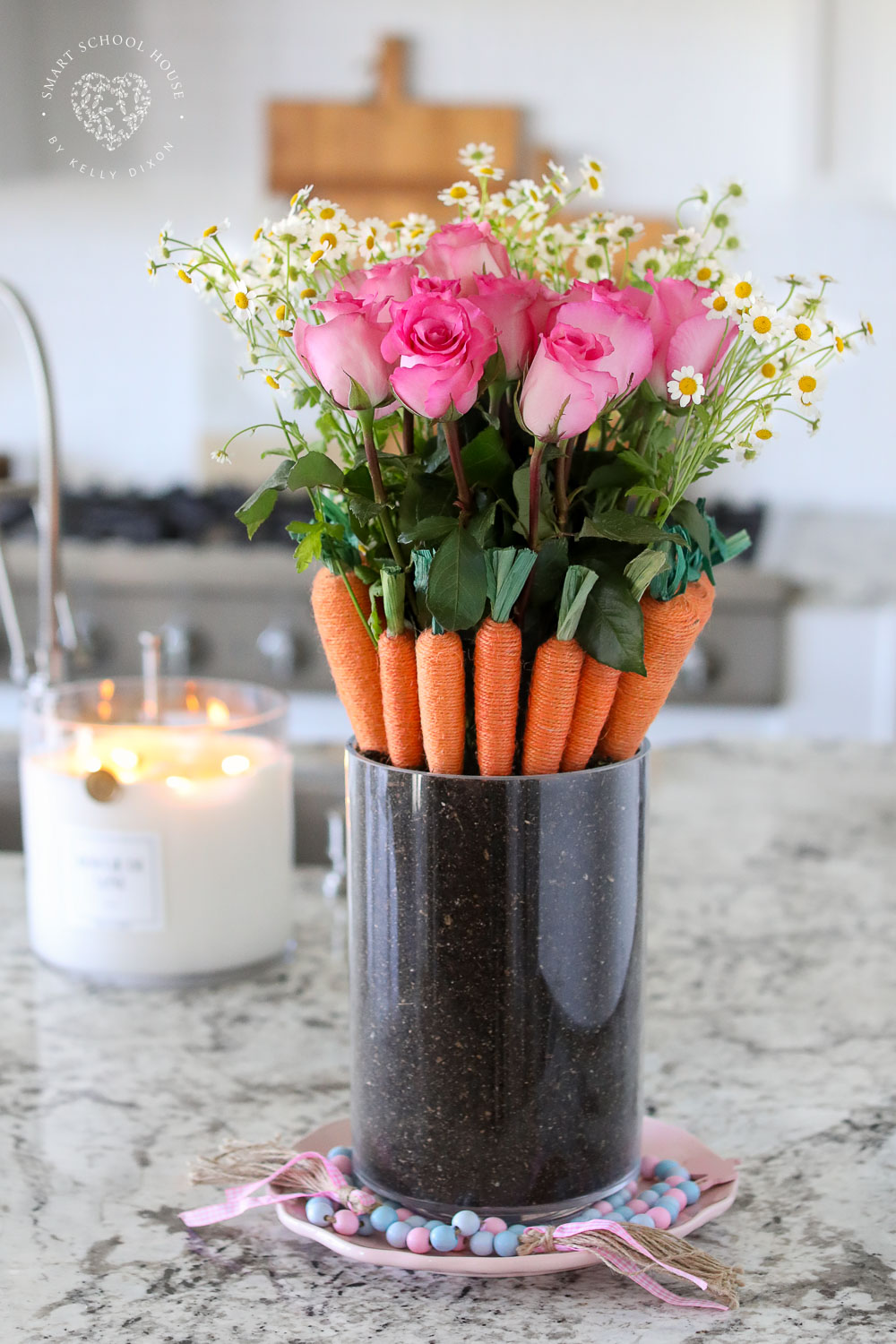 A pretty Carrot Patch Bouquet for Easter and spring! Fresh flowers sit inside of a hidden vase surrounded by carrots nestled in soil.